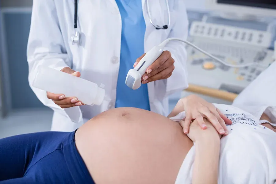 Doctor performing an abdominal ultrasound scan on a pregnant woman