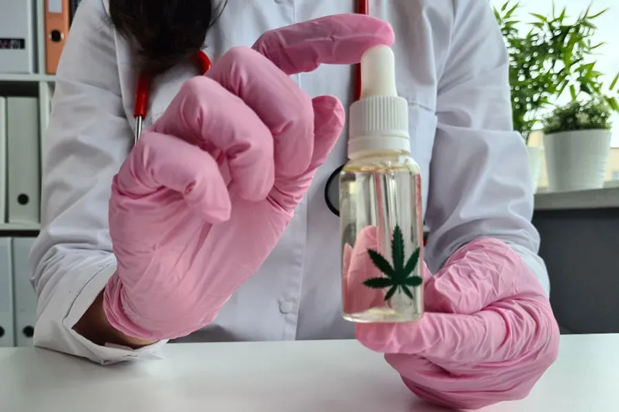 Bottle of medical marijuana oil held in a gloved hand